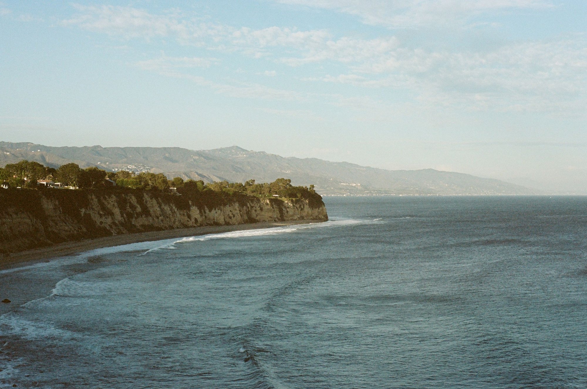 Sunlit California coastline and blue Pacific water