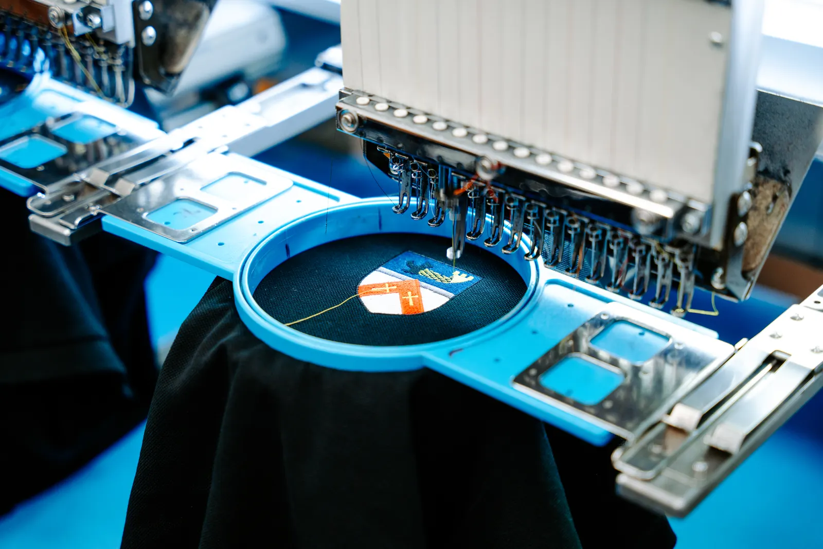 A multi-head embroidery machine stitching a logo at Select Branding in Leeds
