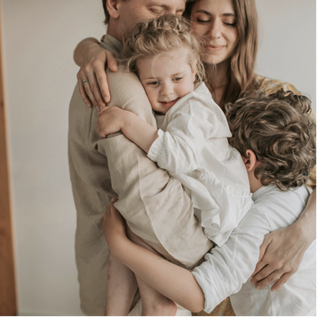 Happy family hugging after a child’s awake ear tube procedure with little to no downtime.