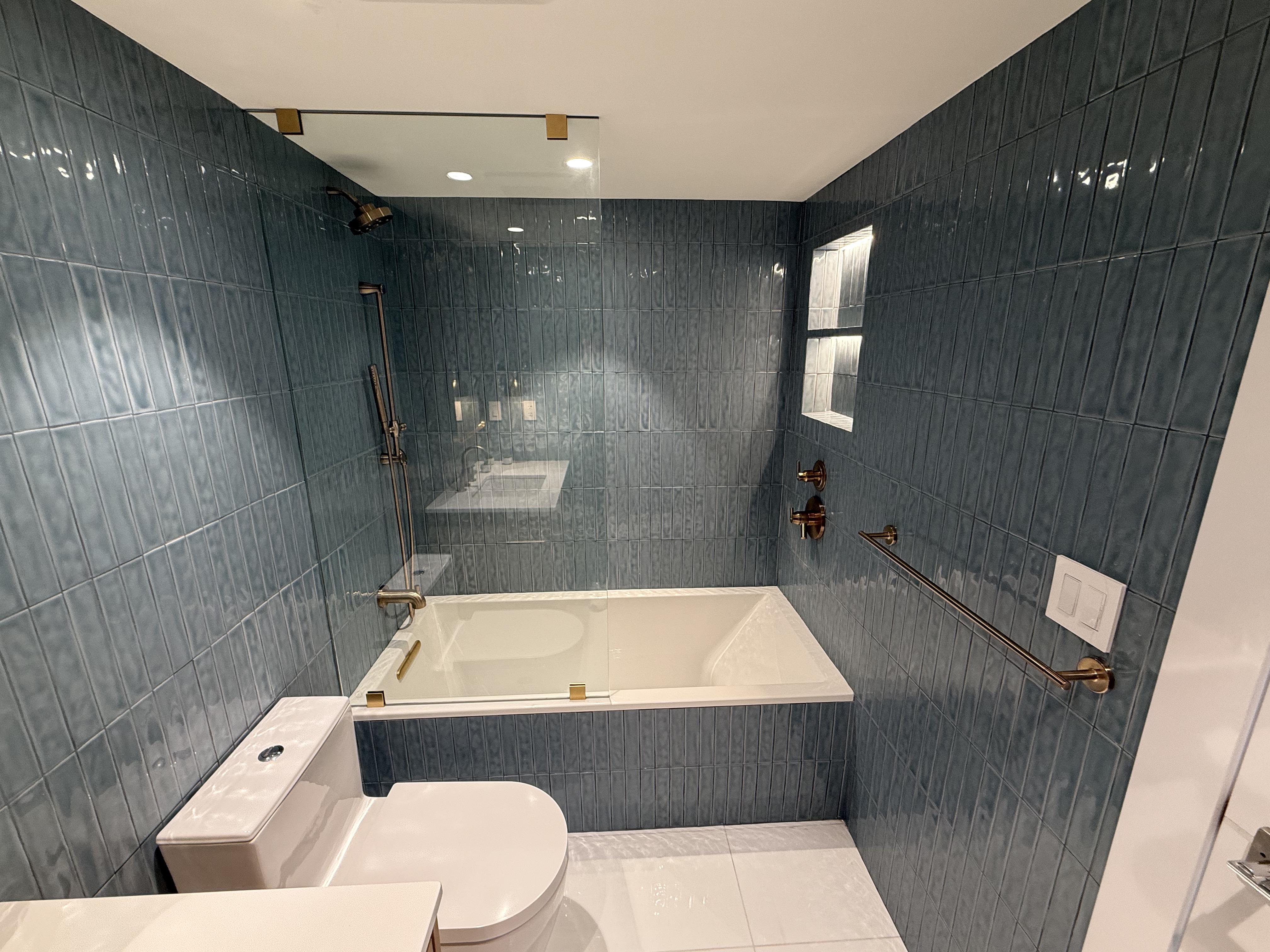 Full bathroom renovation in Brickell Miami — custom tile work and frameless shower by MGA Builders Group