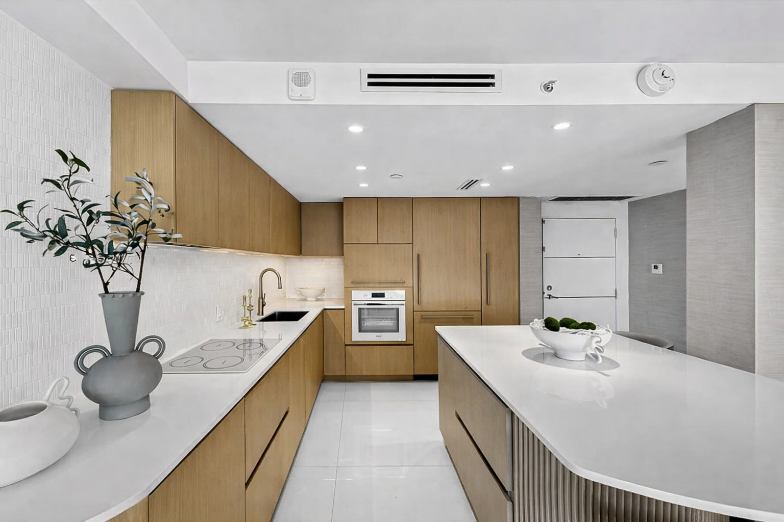 Open concept kitchen renovation in Coral Gables Miami — quartz island and custom storage by MGA Builders Group