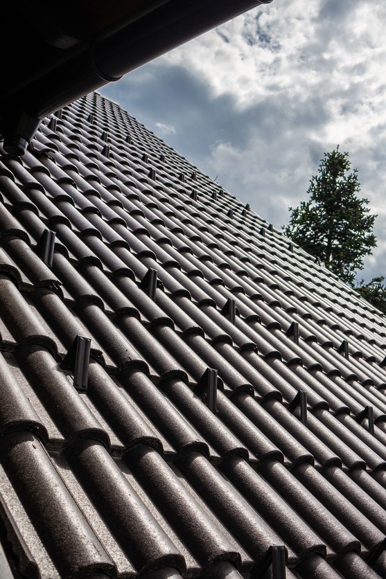 Close-up of a durable, tiled roof under clear skies, representing high-quality roofing solutions provided by .