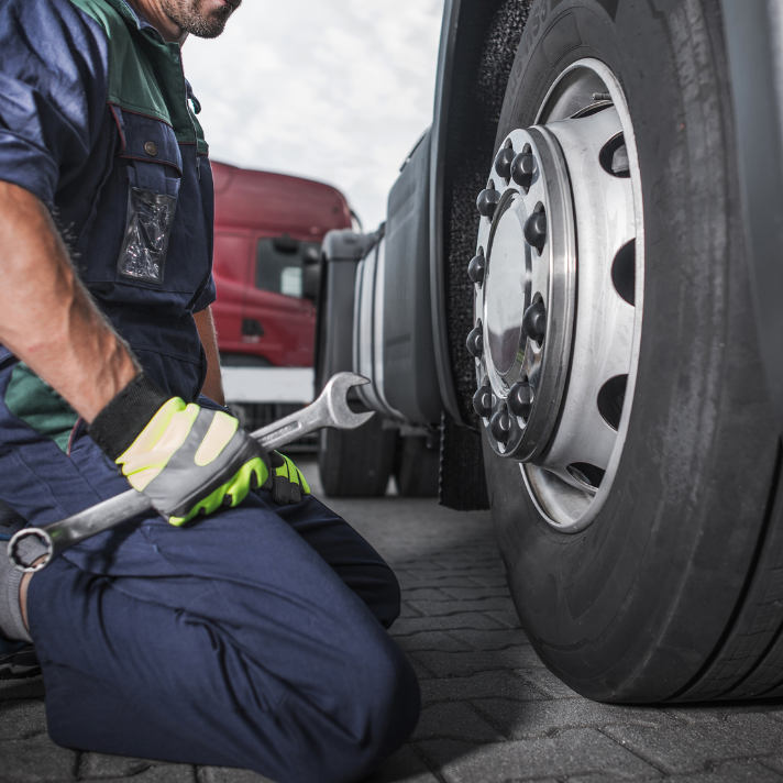 Mechanic working on the wheel of a large truck during a tire service.