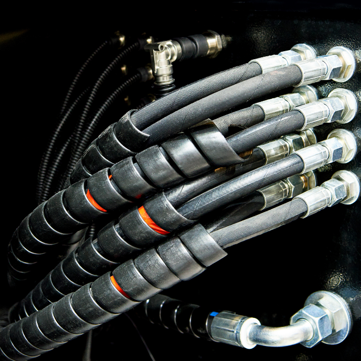 Close-up of hydraulic hoses and fittings used in fleet maintenance.