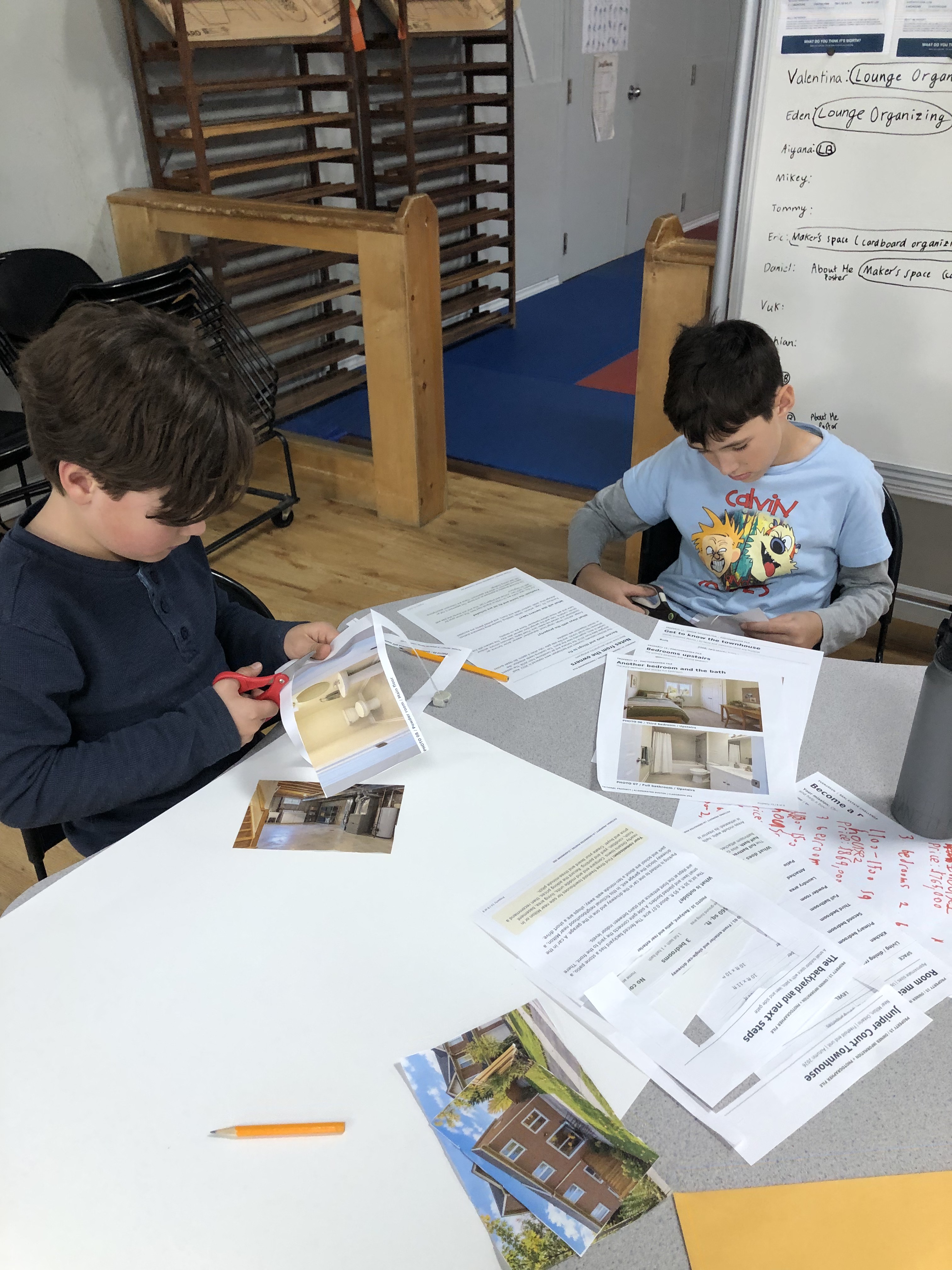 Two Evergreen students cutting out pictures for a classroom project.