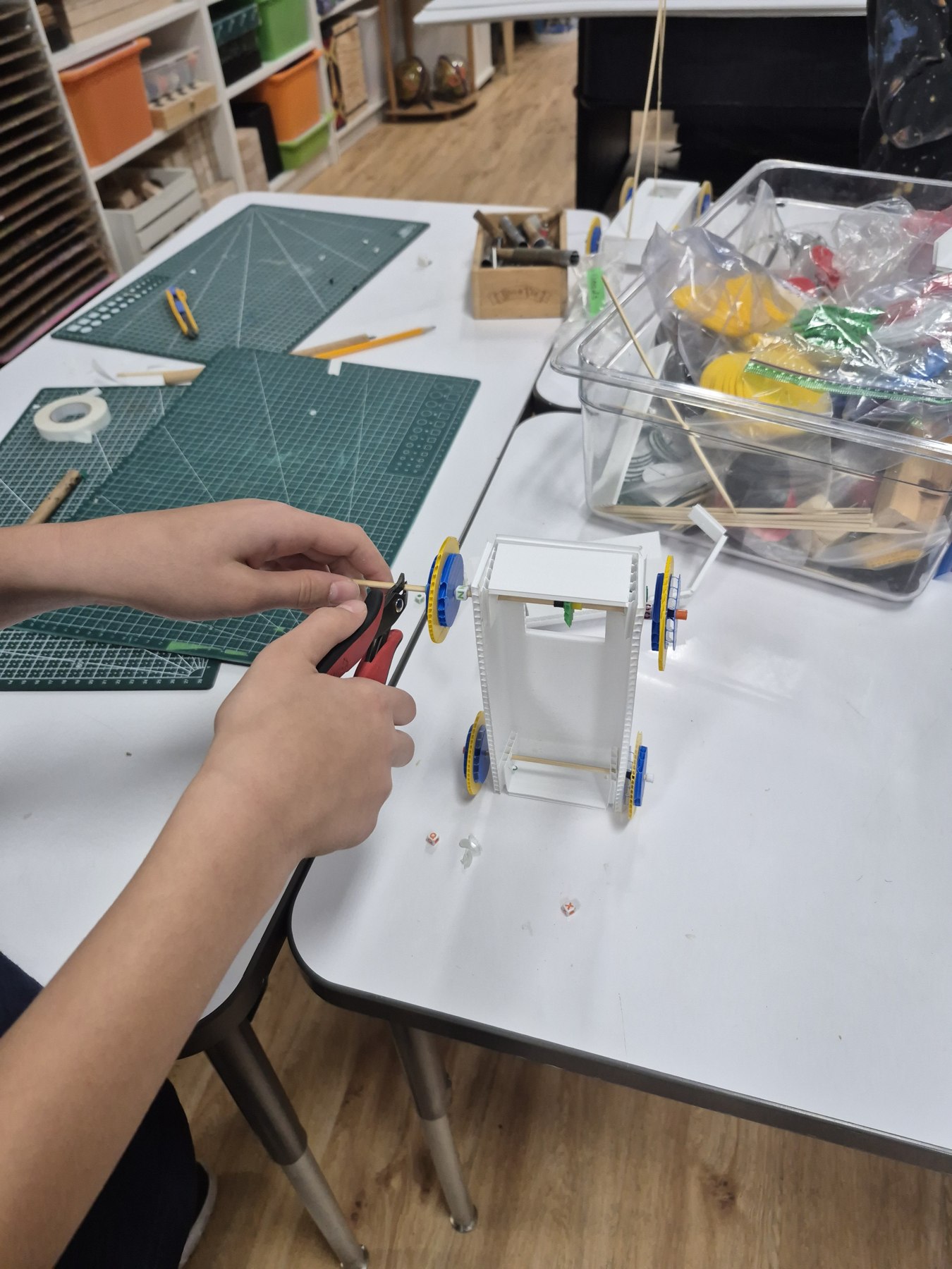 Close-up of hands working with a model and tools at Evergreen Leadership Academy.