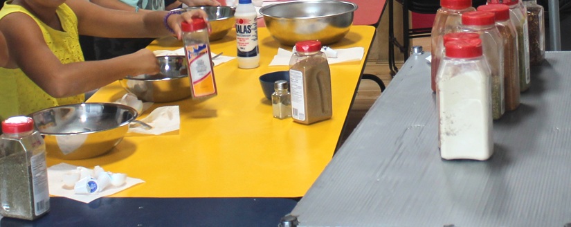 Students working with mixing bowls and ingredients during a school cooking activity