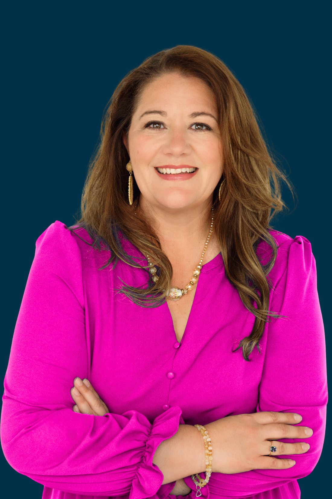 Wendy Hoerl in a magenta blouse, arms crossed, smiling