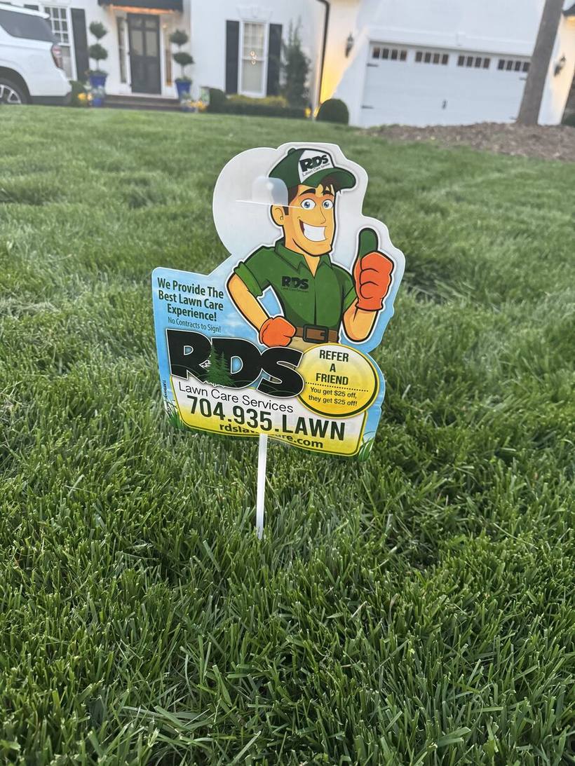 An RDS Lawns yard sign standing in a thick, healthy green lawn