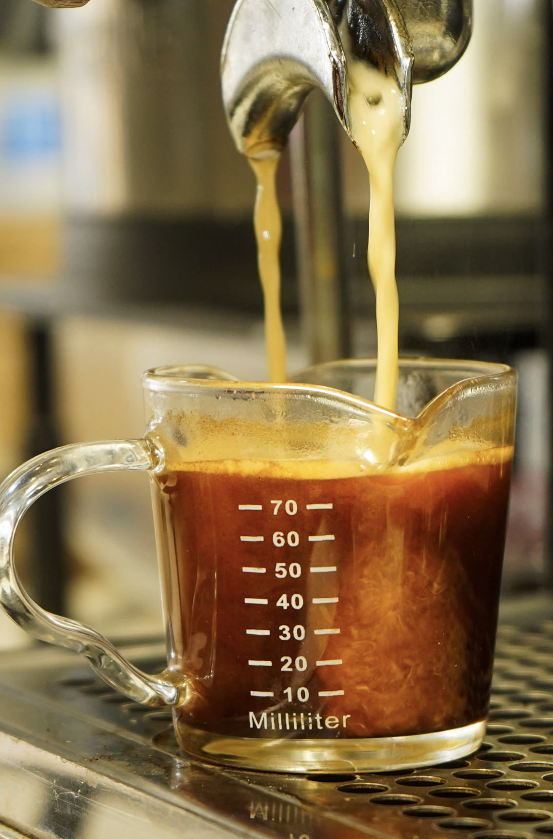 Espresso pouring into a measuring glass