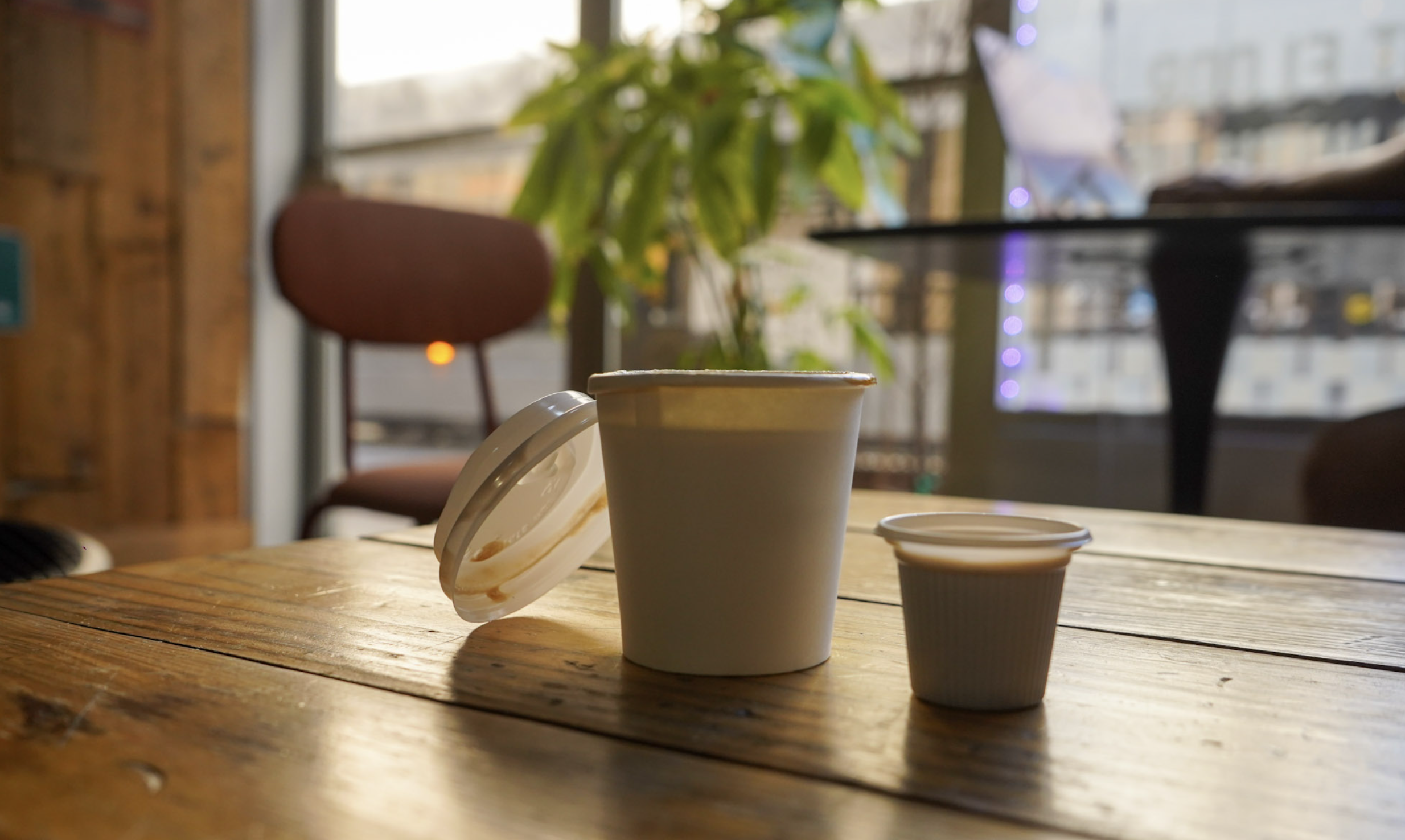 Cortadito and colada on a wood table by the cafe window