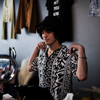 Team member trying on a thrifted patterned shirt