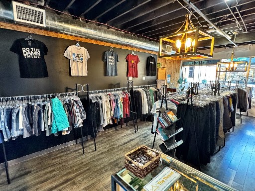Inside The Thread thrift shop, racks of clothes and tees on the wall