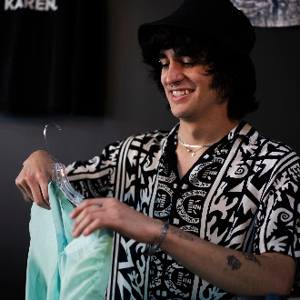 Team member holding up a thrifted shirt