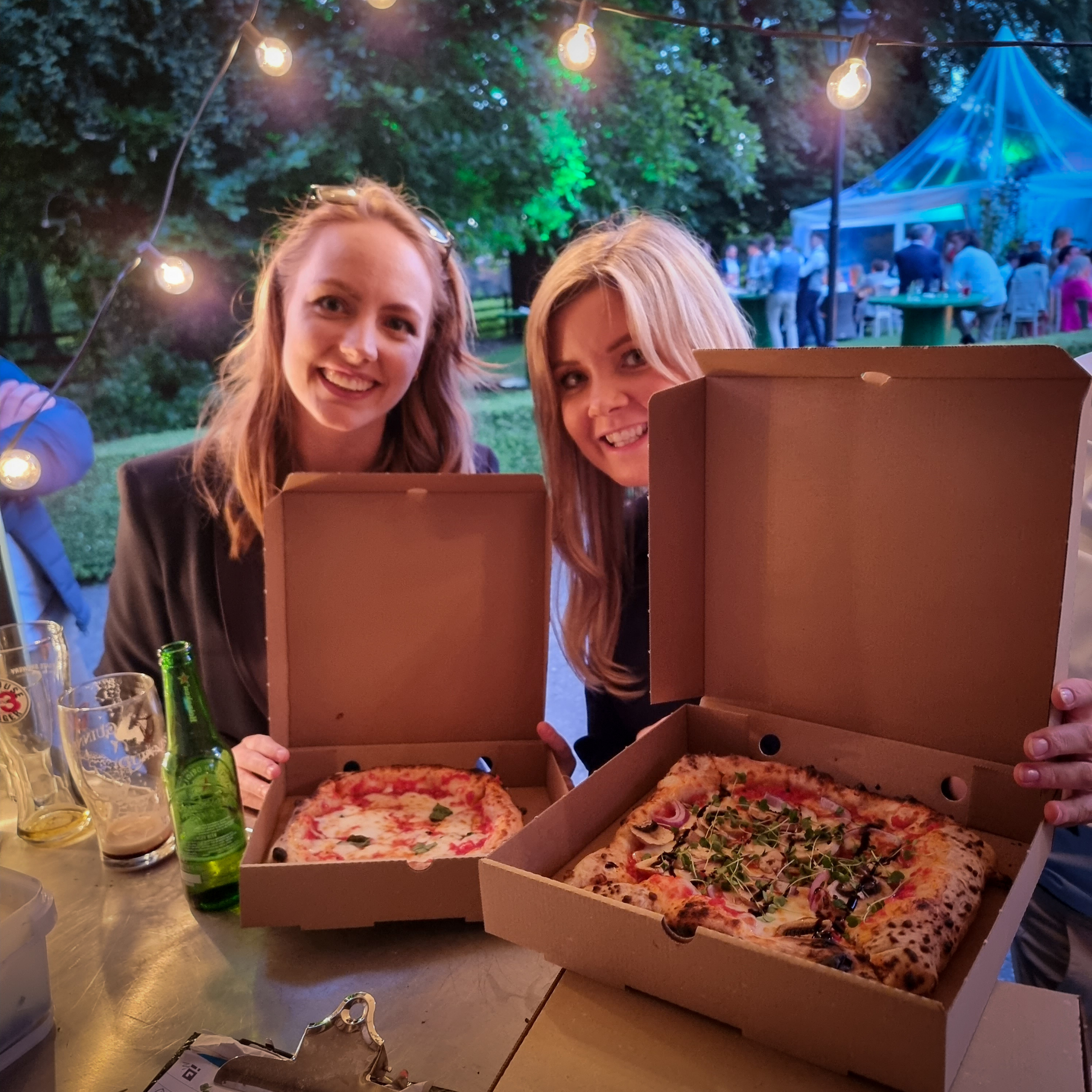 Colleagues smiling together with freshly cooked Garlic and Thyme pizzas