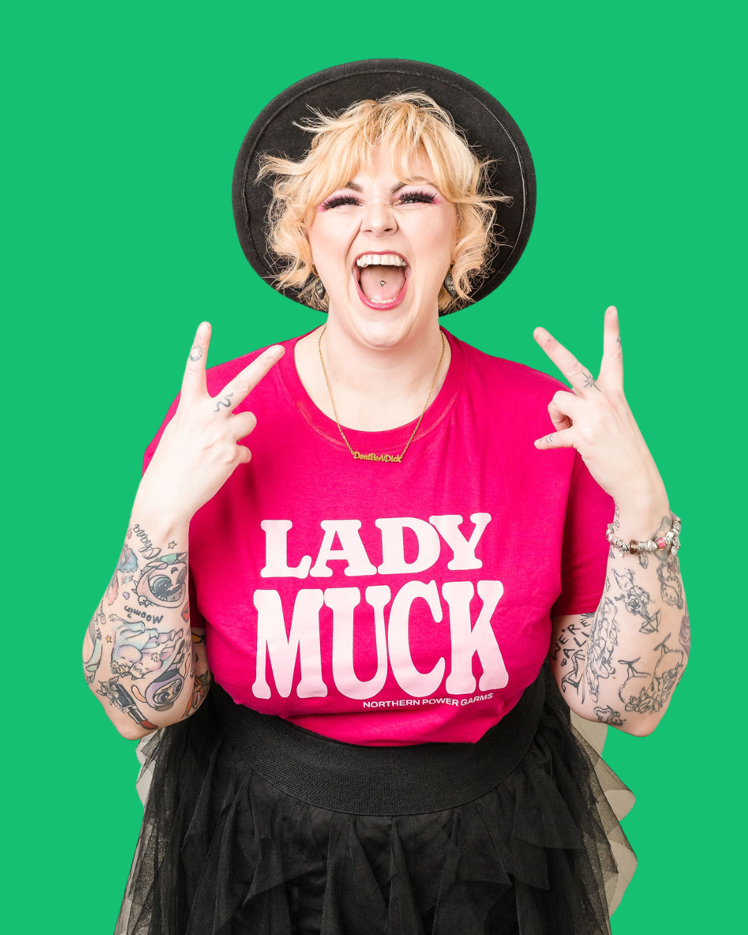Kim Antrobus throwing rock horns in a Lady Muck t-shirt