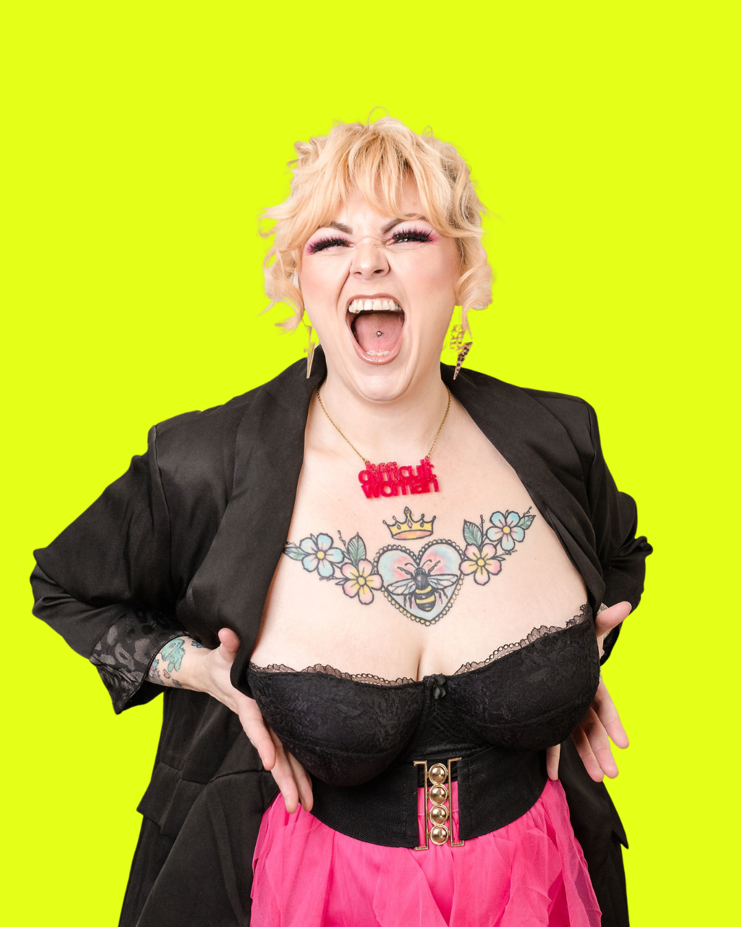 Kim Antrobus roaring with hands on hips against a neon yellow background