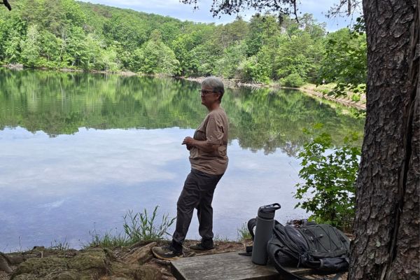 Claudette Eames standing beside a peaceful lake in South Carolina reflecting on growth, resilience, and the choices that shaped her life after loss.