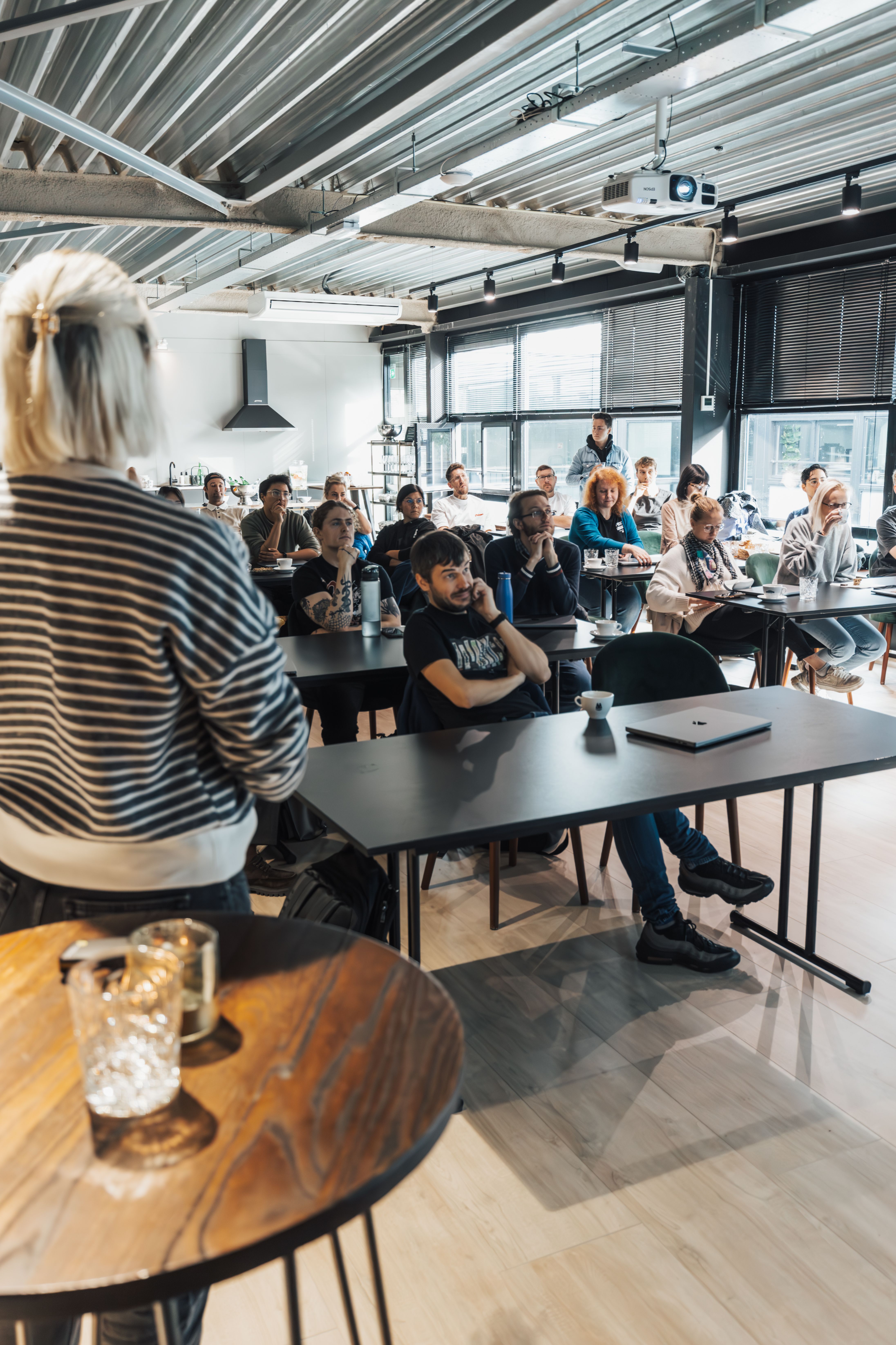 Facilitator leads a nervous system-based change workshop for leaders and teams in a modern training room.