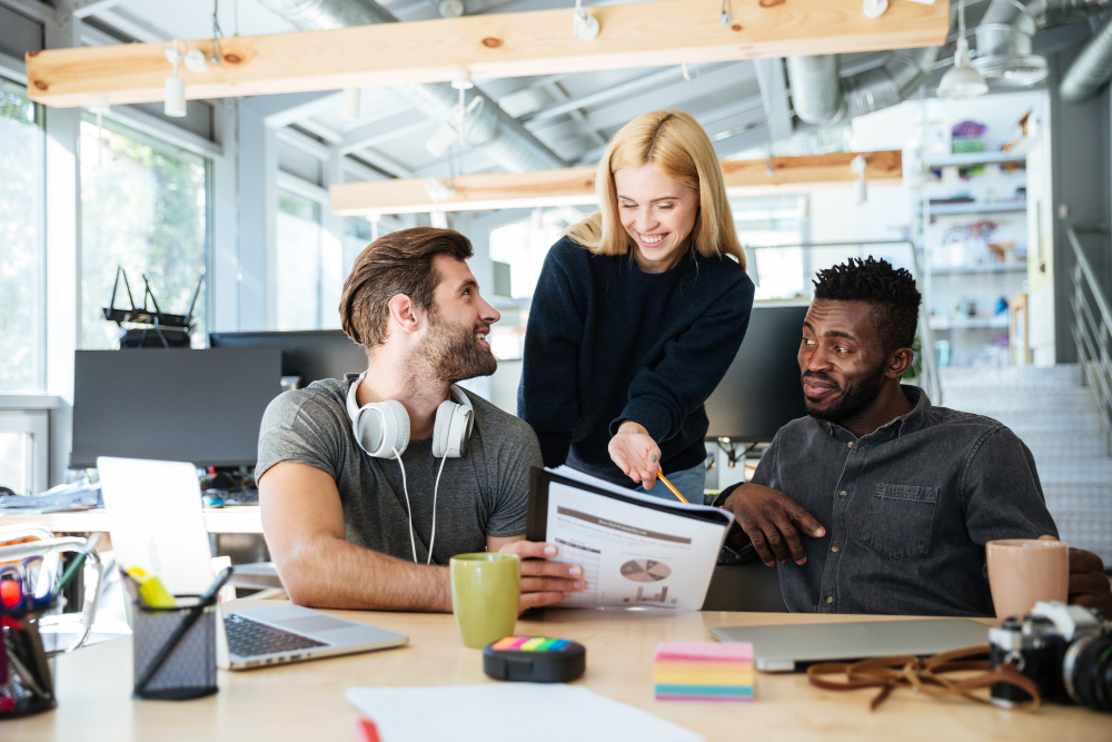 Team members reviewing campaign performance reports together in a modern office setting. Team members reviewing campaign performance reports together in a modern office setting.