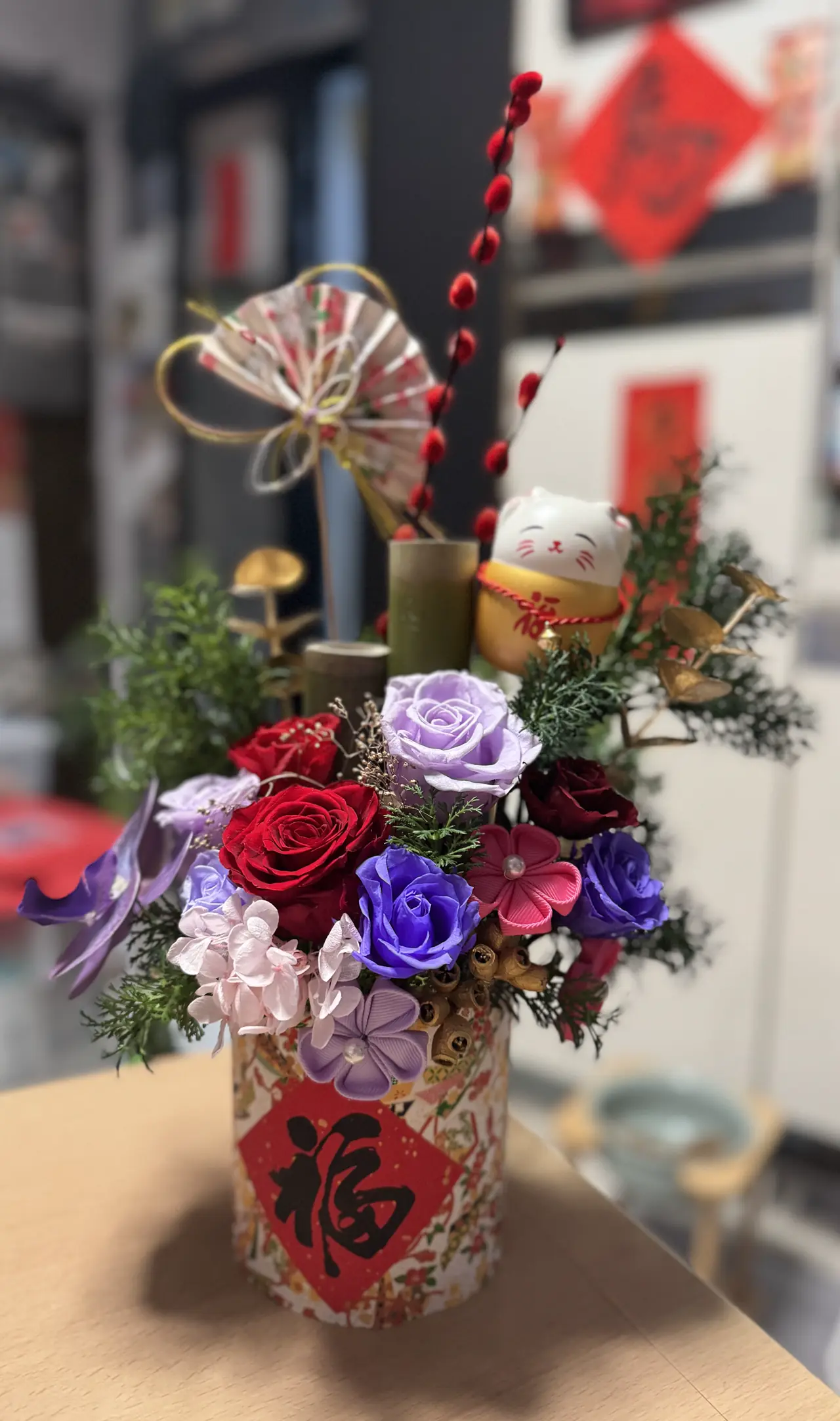 保鮮花搭配小揮春與金色裝飾的新年桌花擺設，念念花藝學院 LLFA 學員在家完成作品