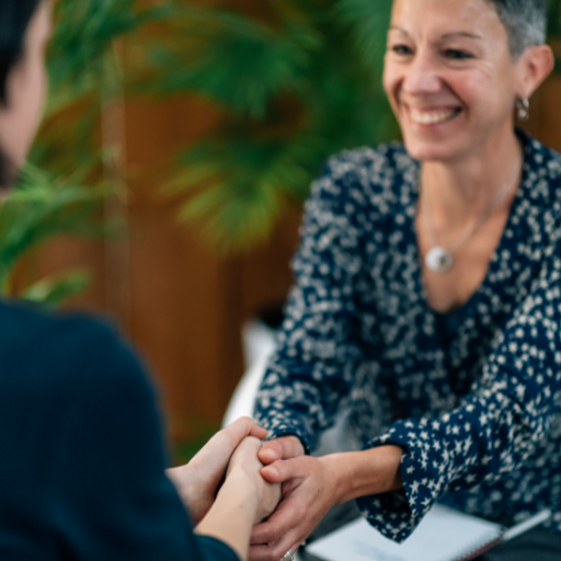 Woman coach holding client’s hands during a session, showing connection, support, and transformation Woman coach holding client’s hands during a session, showing connection, support, and transformation