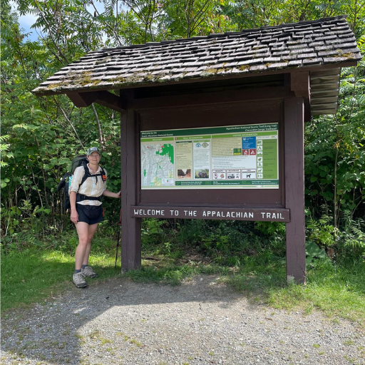 Tracie standing beside the Welcome to the Appalachian Trail sign Tracie standing beside the Welcome to the Appalachian Trail sign