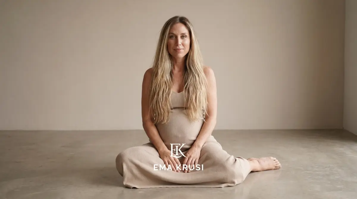 Portrait d'une femme enceinte assise au sol, les mains posées sur son ventre, illustrant la connexion avec son bébé, le calme intérieur et la confiance pendant la grossesse.