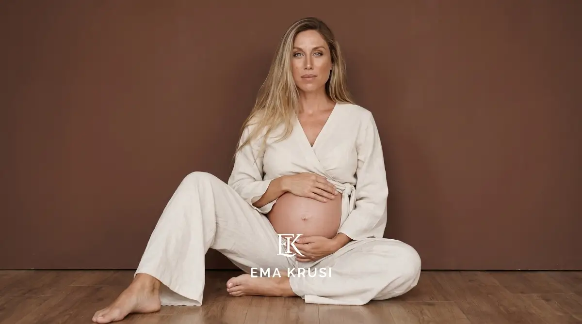 Portrait studio d'une femme enceinte sur fond brun, mettant en valeur la maternité, la force féminine et la beauté naturelle de la grossesse dans une ambiance sobre et élégante.