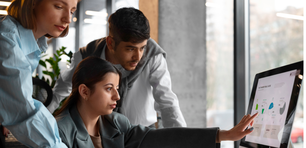 A team of professionals collaborating while analyzing data on a computer screen, representing managed IT services.