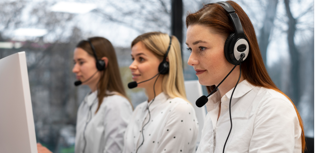 A team of customer support representatives wearing headsets and providing remote IT support as part of managed IT services