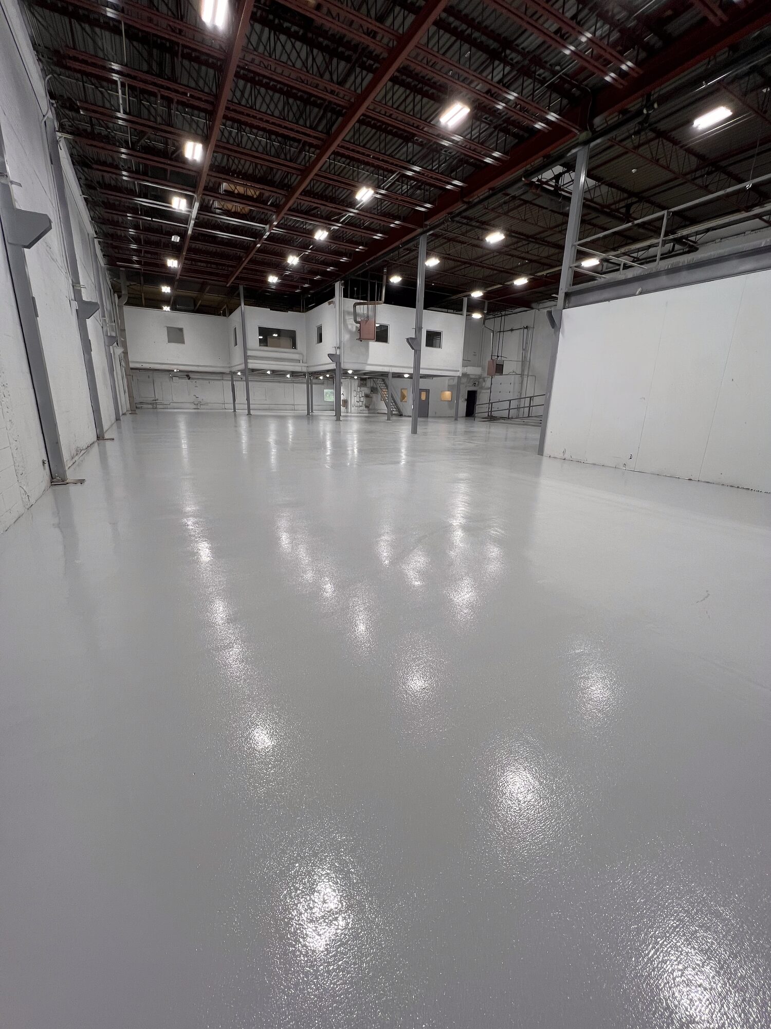 Completed commercial epoxy floor across a large warehouse