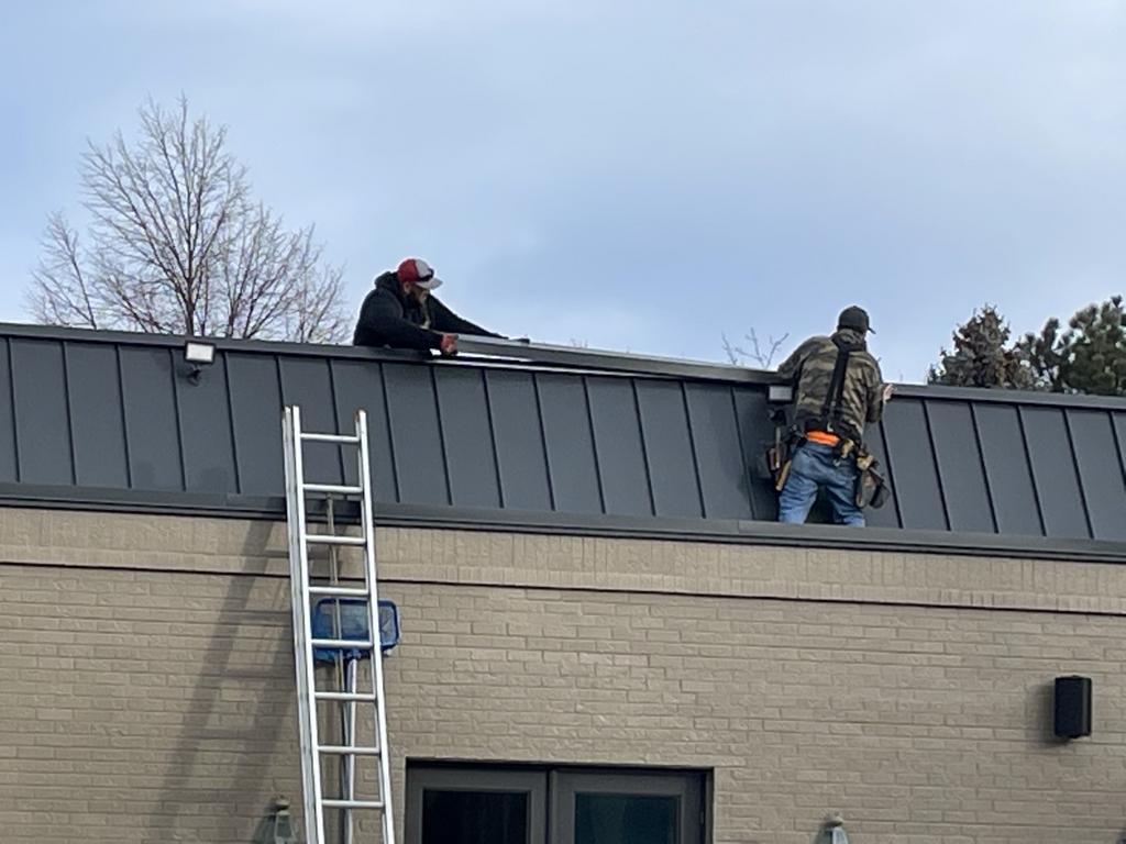Roofer fixing damaged shingles on a home in Parker, CO
