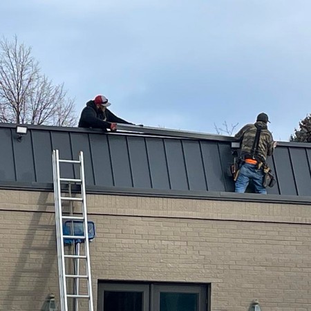 Roofing crew replacing asphalt shingles on Parker home