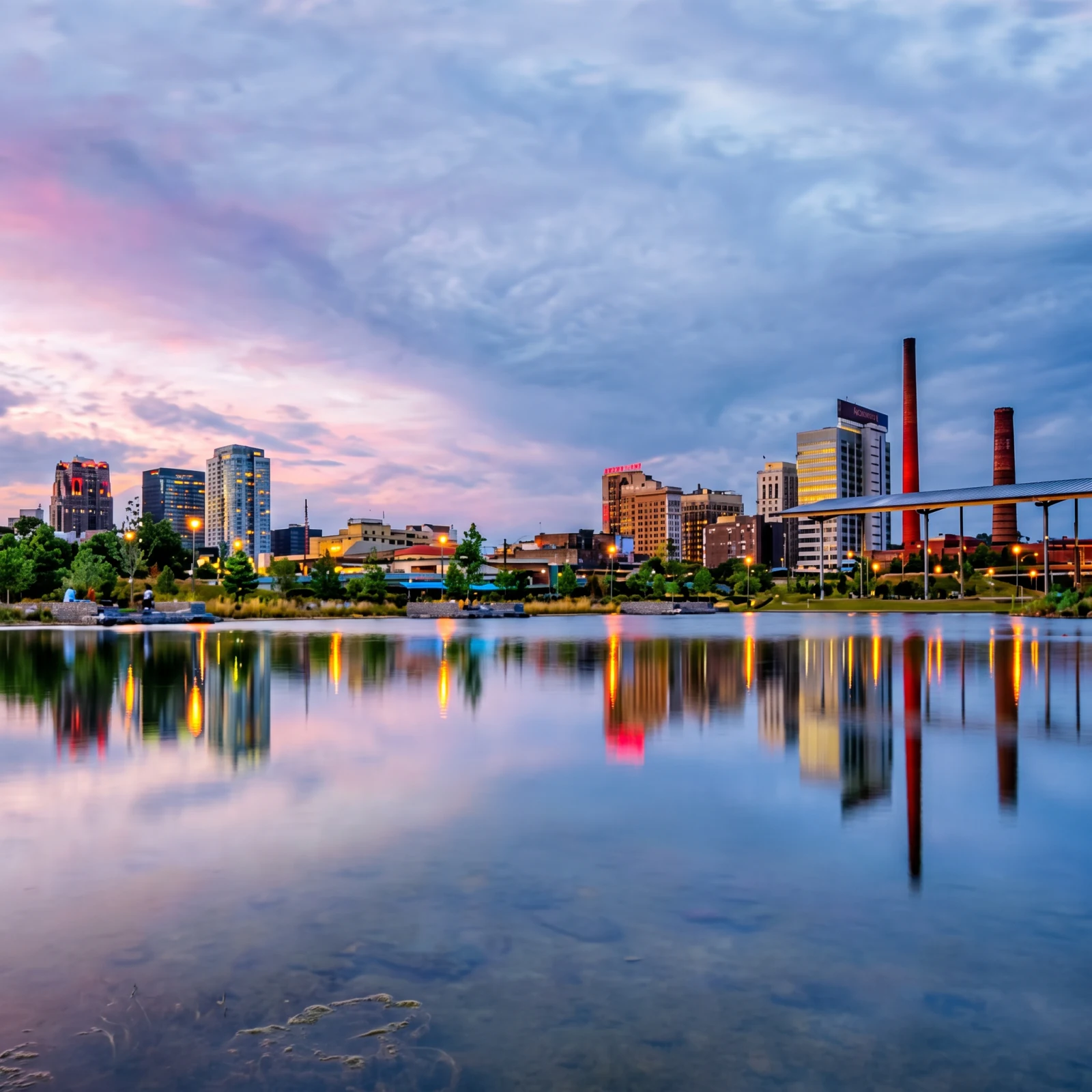 Birmingham, Alabama skyline at dusk reflected in the water at Railroad Park