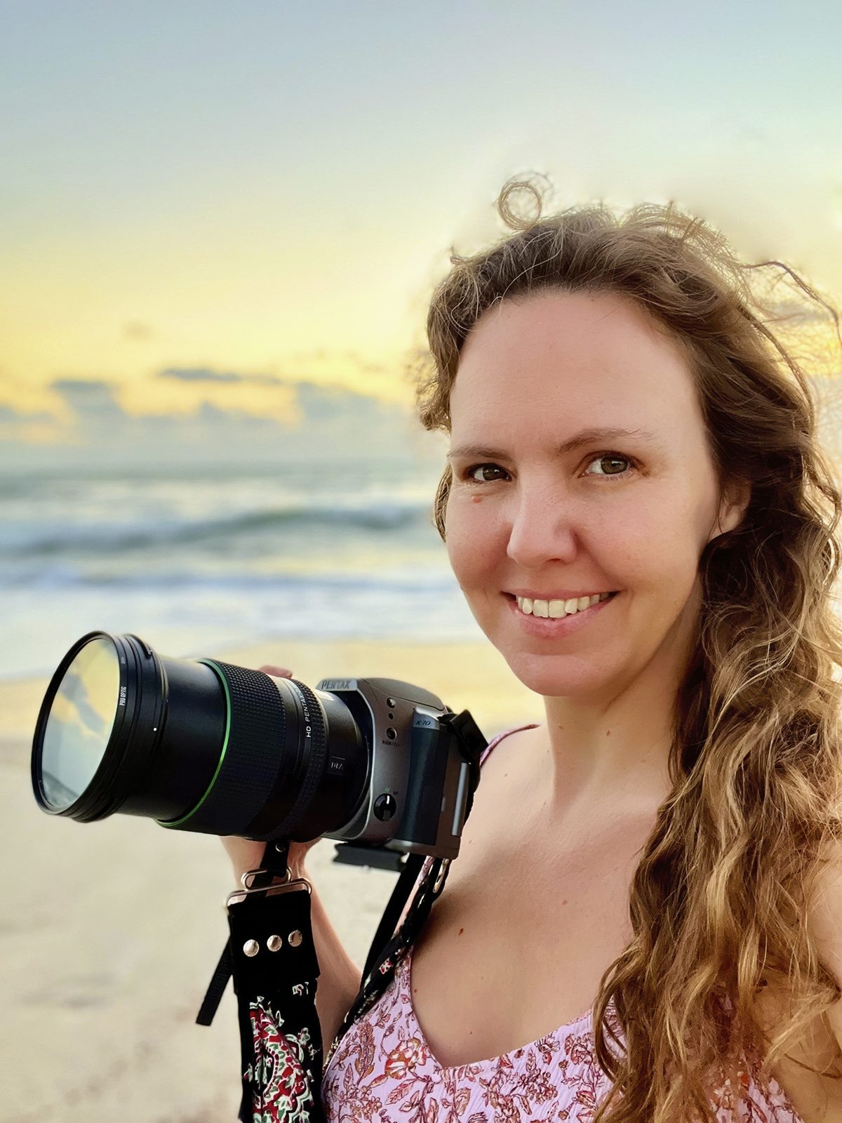 Rhiannon Tunnell holding her camera on the beach in Melbourne, Florida