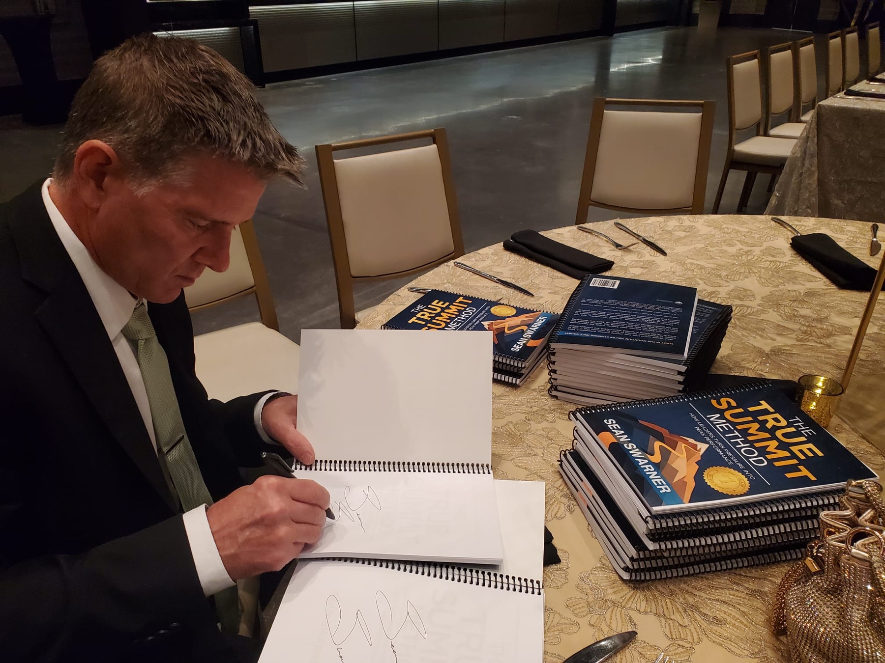 Sean Swarner signing copies of The True Summit Method at an event