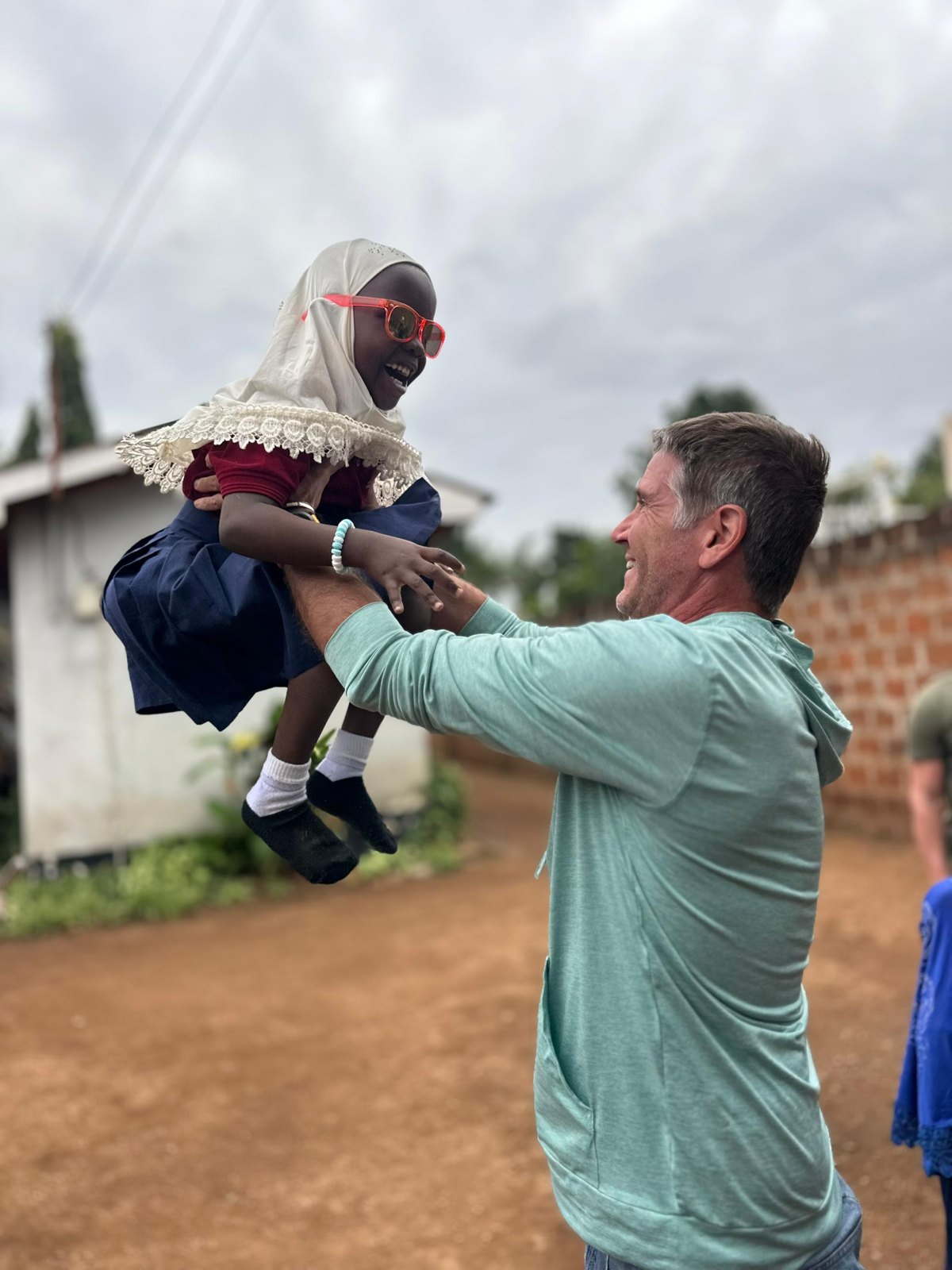 Sean lifting a schoolgirl in Tanzania