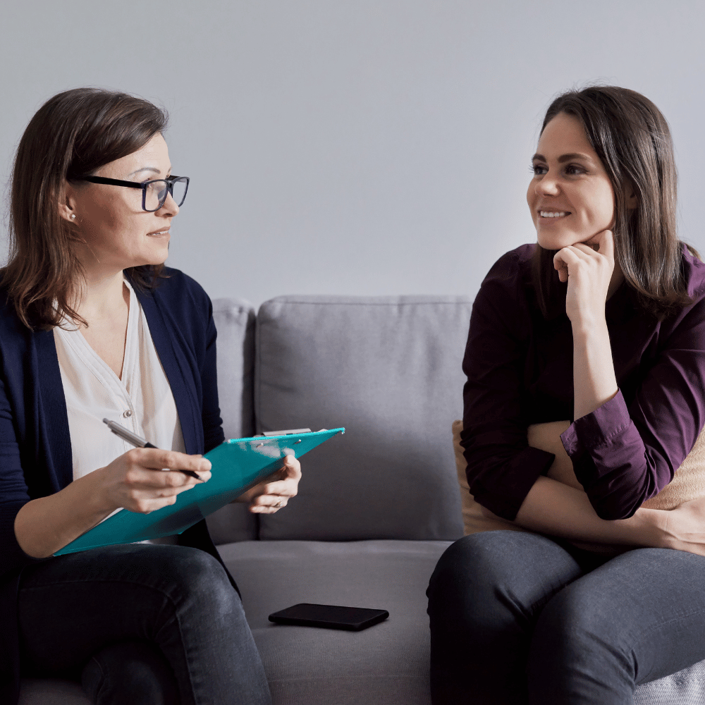 An image of two women talking on a couch