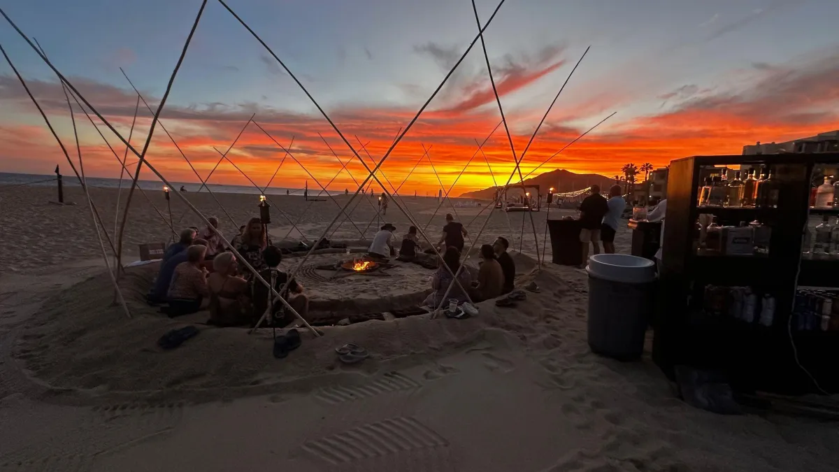 Beach bonfire gathering at sunset