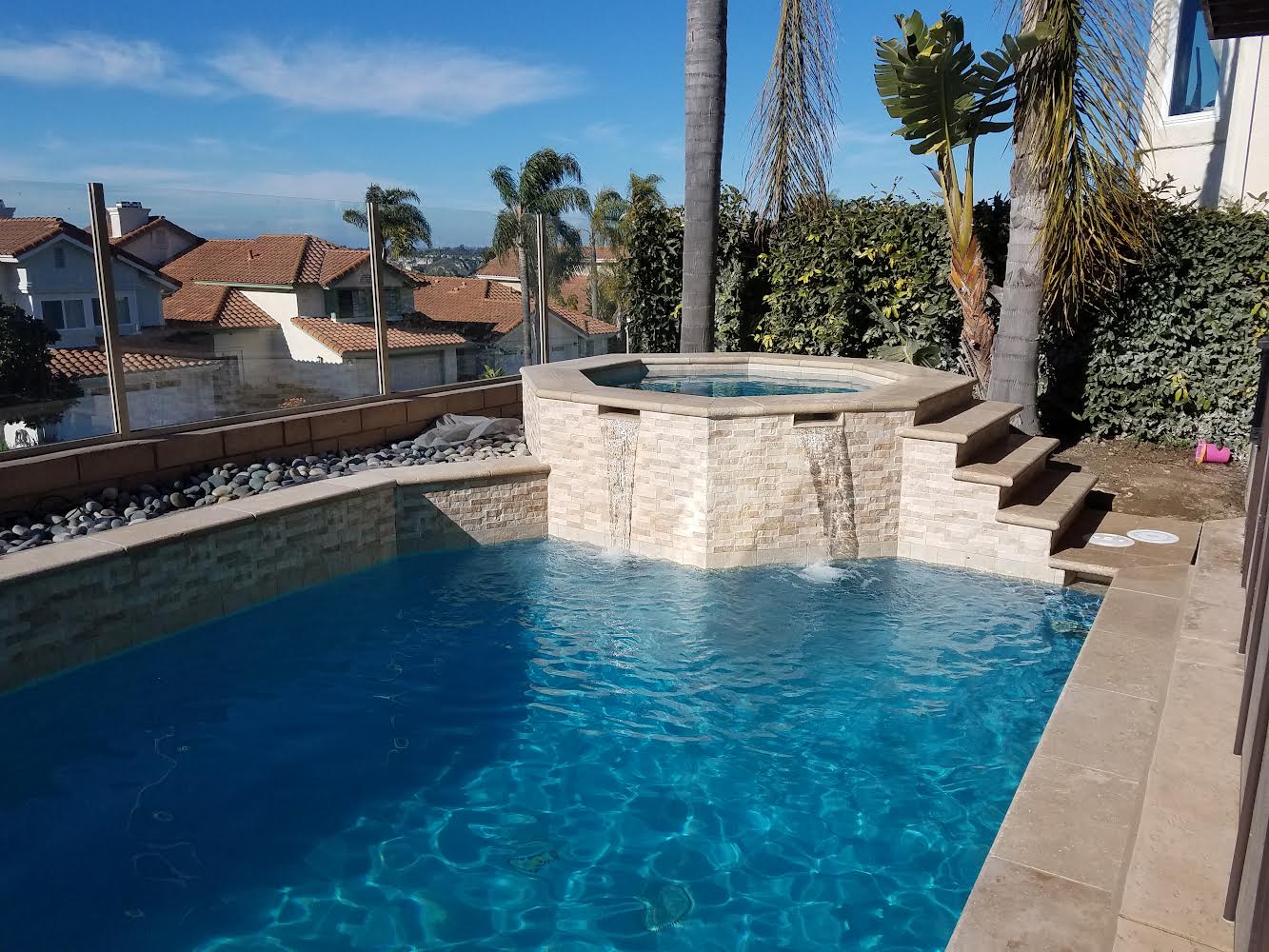 Raised spa with sheer-descent waterfalls and stone coping