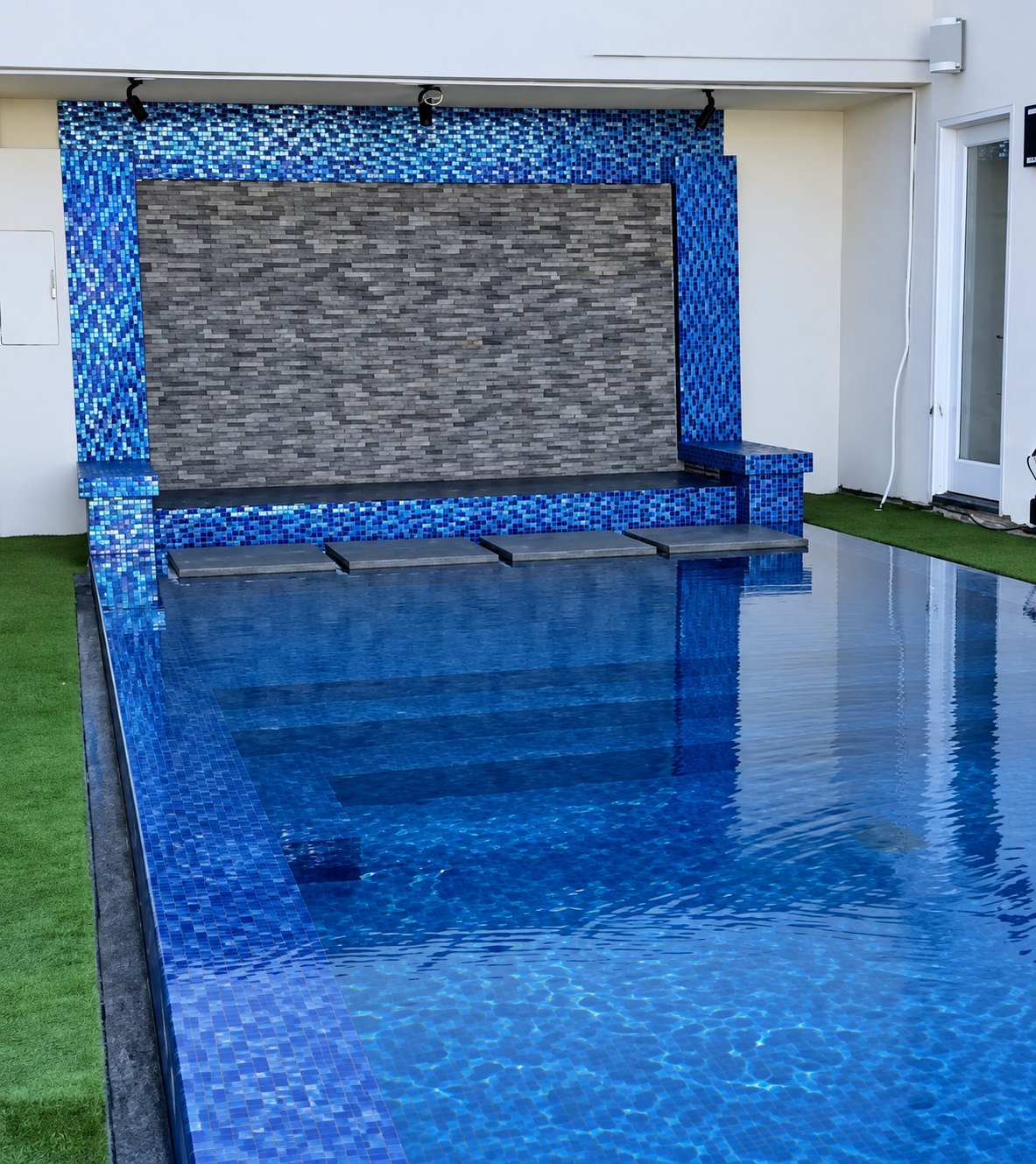 Blue glass tile spillway wall on a remodeled pool