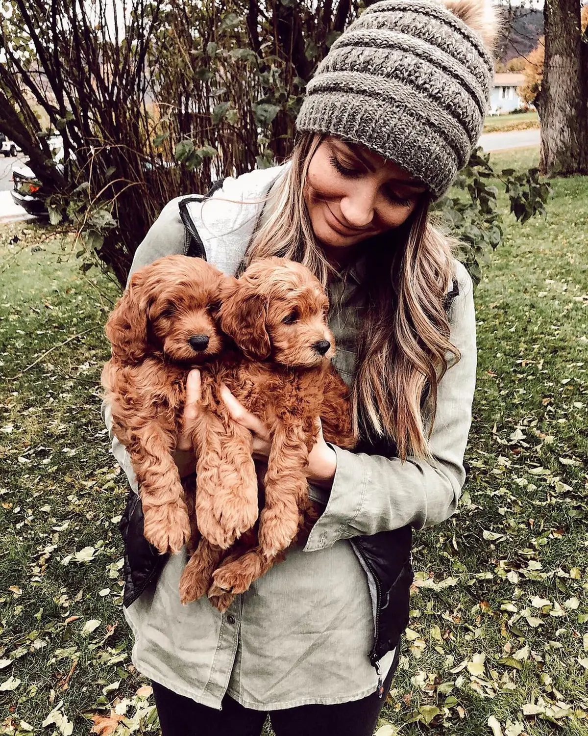 Tiarra Brummond holding two red doodle puppies