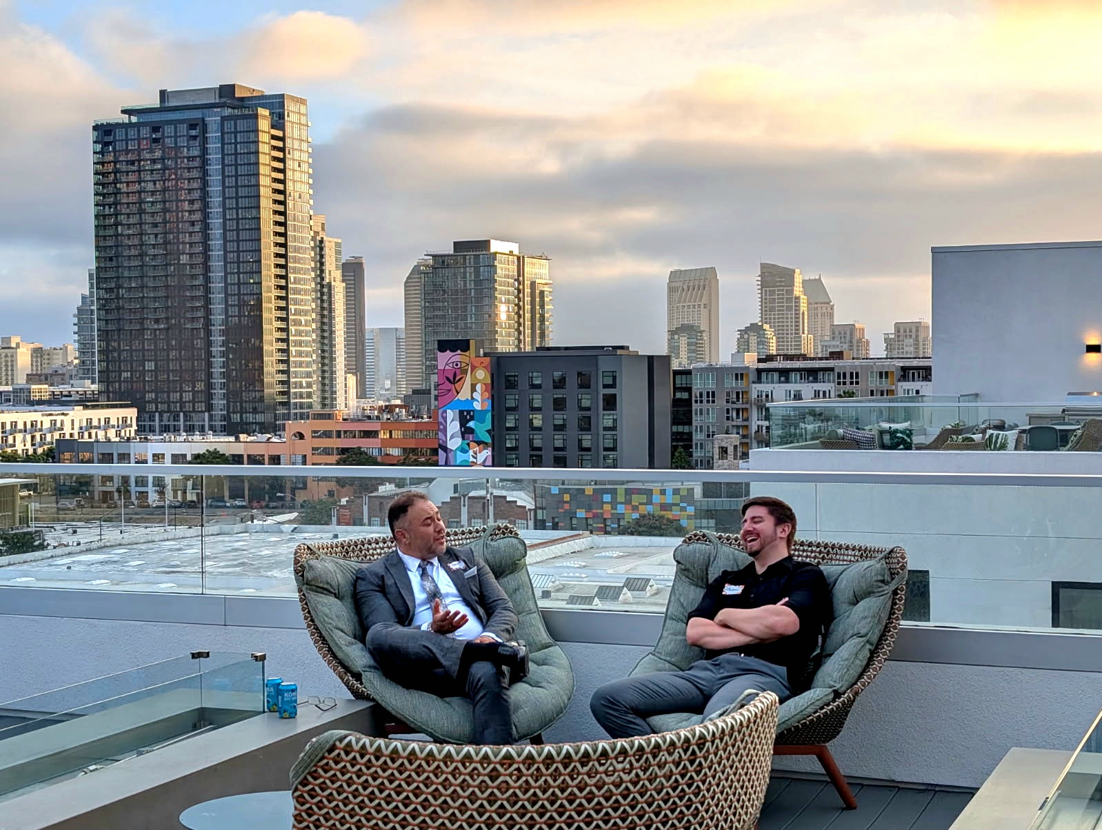 Rob Garcia in conversation on a rooftop overlooking the city skyline