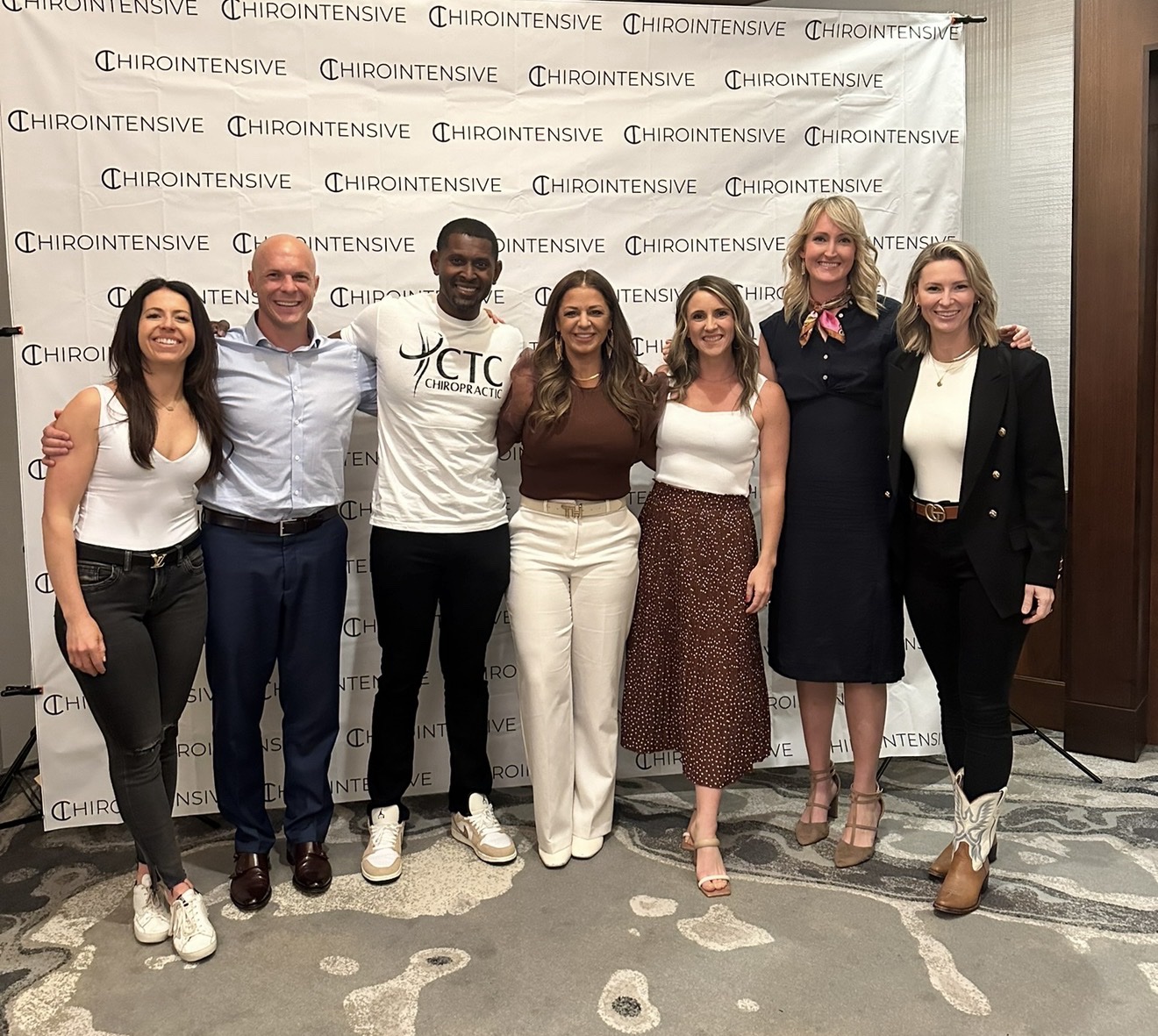 ChiroIntensive members together in front of the step-and-repeat backdrop