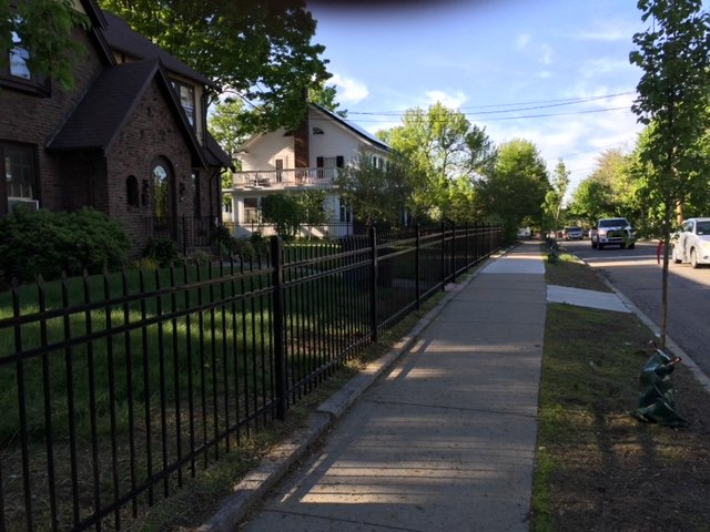 Black aluminum fence along a sidewalk by All Fenced In