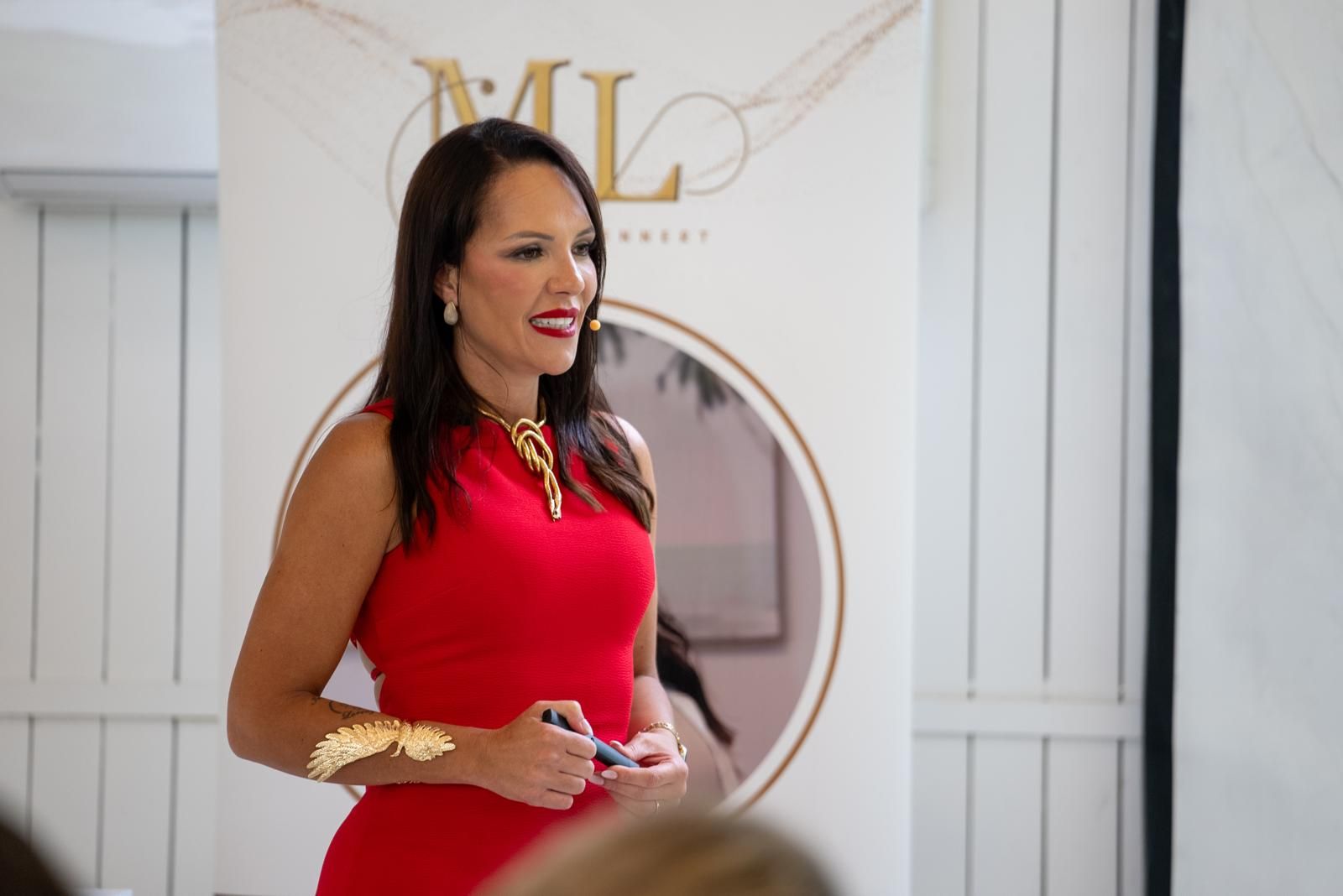 Mariana in red, speaking to women at a workshop
