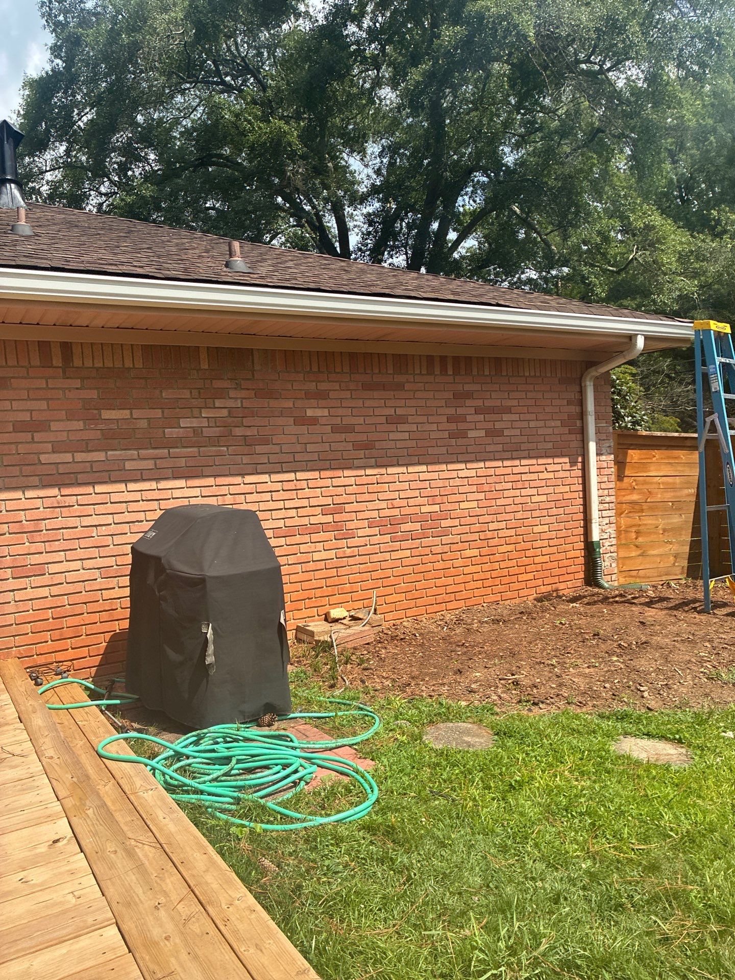 Aluminum downspout running down a brick exterior wall