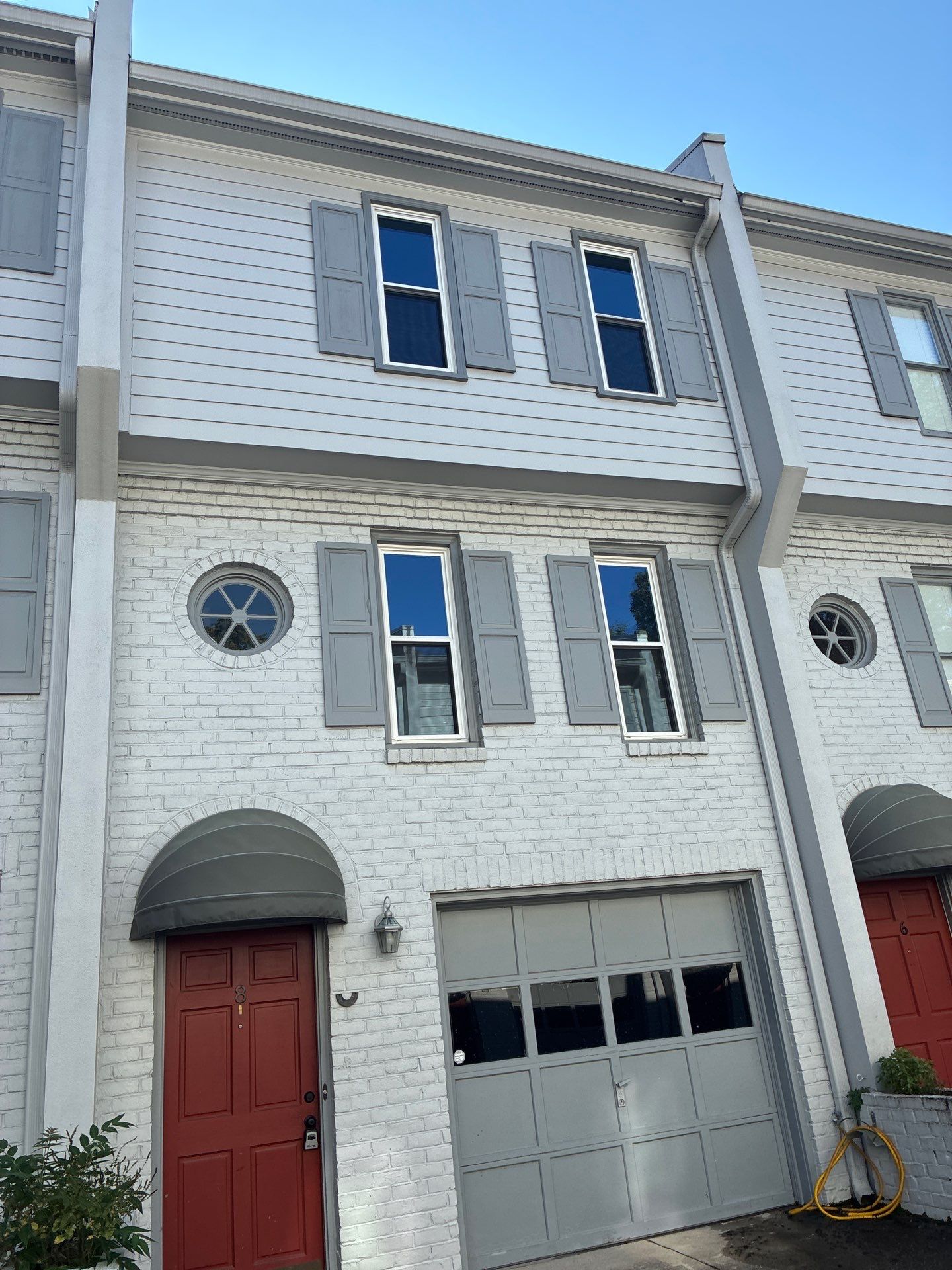 Two-story townhome exterior with downspouts running down the corners