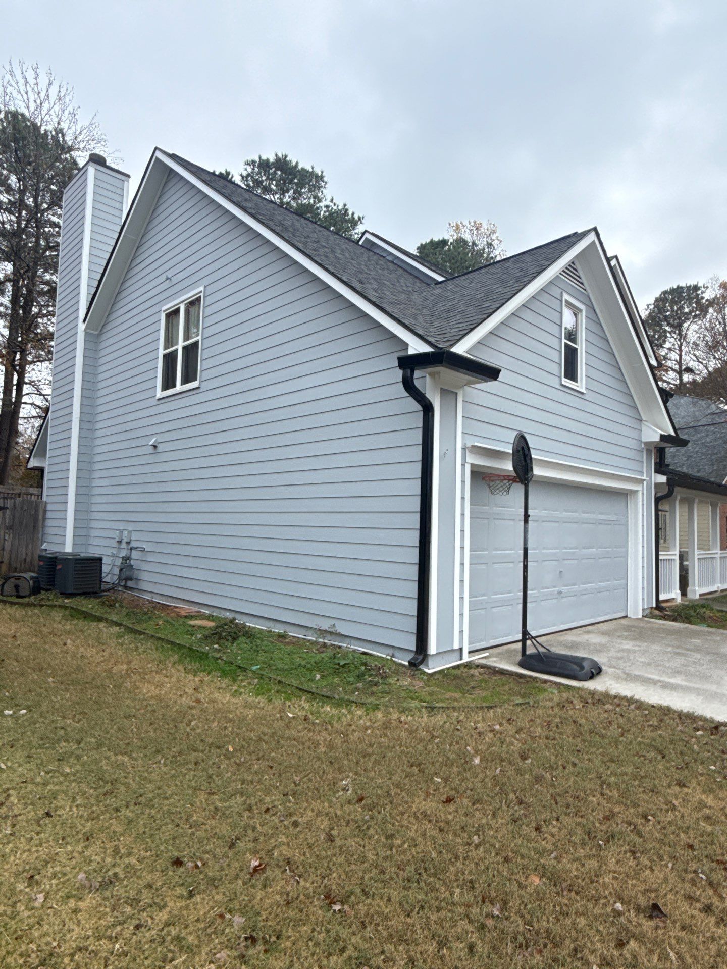Downspout running straight and solid along the corner of a house, no visible damage